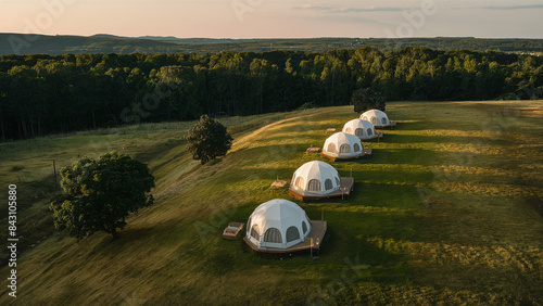 a distributed glamping wooden geodesic domes in the hills, indie alternative eco-friendly vacations, low-impact green architecture, harmony with nature