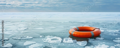 Orange lifebuoy floating on a frozen lake is giving hope for survival