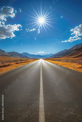 Asphalt road through barren desert, empty and inviting, adventure scene, bright sunlight