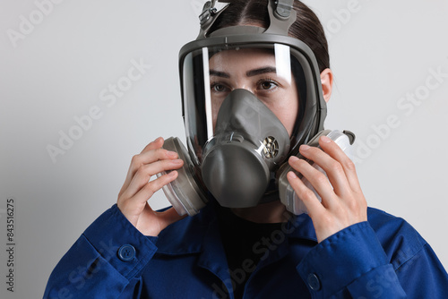 Worker in respirator mask on grey background