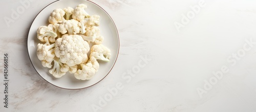 Plate with cut fresh raw cauliflower on light grey table top view Space for text. copy space available