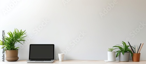Flat lay composition with copy space of white desk table on home office Notebook blank sheets of paper pen and computer keyboard and a green plant as decoration