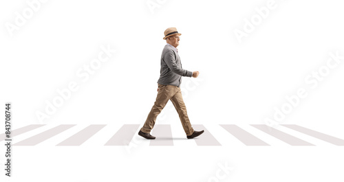 Full length profile shot of an elderly gentleman walking at a pedestrian crossing