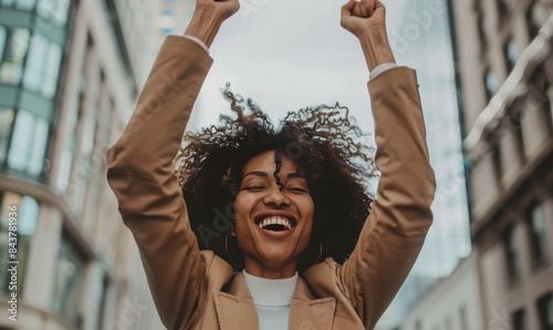 black woman celebrating success in the city with joyful expression