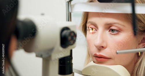 Woman, optometry and slit lamp for vision, test and care in wellness assessment with health at clinic. Doctor, optician and patient by machine, light and laser for retina scan with lens for eye exam