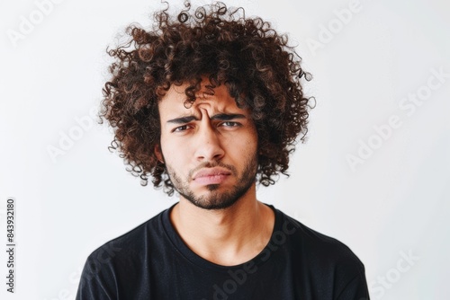 diverse millennial or gen z guy with curly hair looking disappointed or irritated wearing black t-shirt isolated on white mock up template