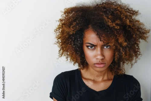 diverse millennial or gen z woman with curly hair looking disappointed or irritated wearing black t-shirt isolated on white mock up template