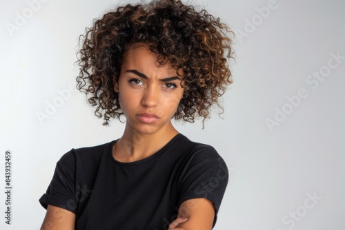 diverse millennial or gen z woman with curly hair looking disappointed or irritated wearing black t-shirt isolated on white mock up template