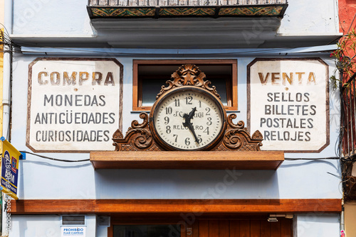 VALENCIA, SPAIN - May 2, 2024: An antique clock hangs above a watchmaker's shop