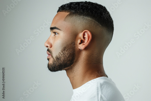 Handsome young man with short hair and beard in side view on white background