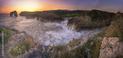 Panoramic view at dawn of the Castro de las Gaviotas, in Llanes, Asturias, with the waves breaking strongly on the cliffs