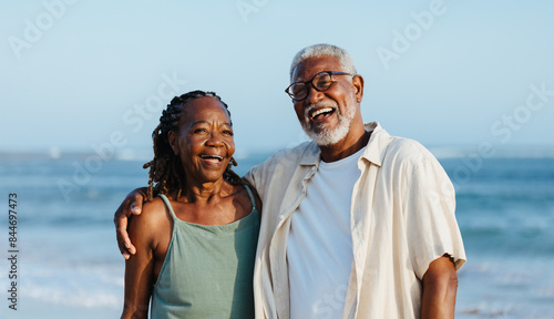 Joyful elderly black couple walking on a beach