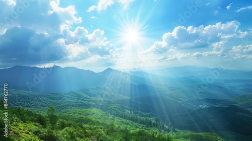 Dazzling sunlight illuminates wild mountain scenery with clear blue sky white clouds and sunbeams shining on hills and trees