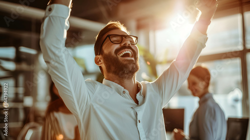 A male businessman in a suit celebrates with raised hands, symbolizing success