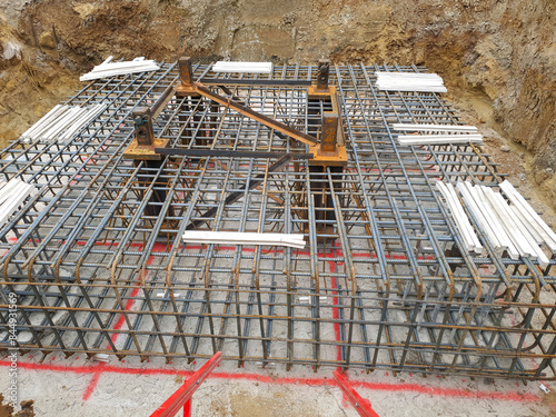 Construction site with tower crane base and mast cast in steel reinforcement. Industrial construction site photography. Foundation and structural support concept for design and documentation. 