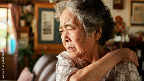 肩を押さえる日本人高齢女性