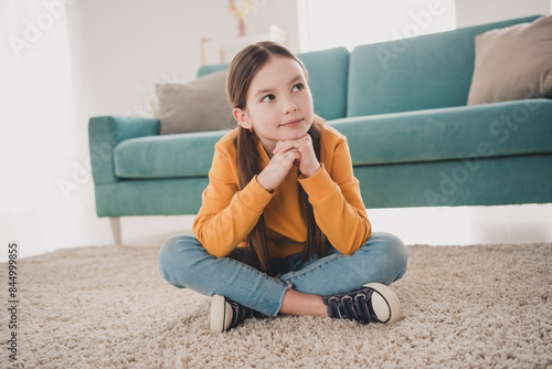 Full size photo of cute little girl wear sweater sitting floor fantasize living room apartment indoors