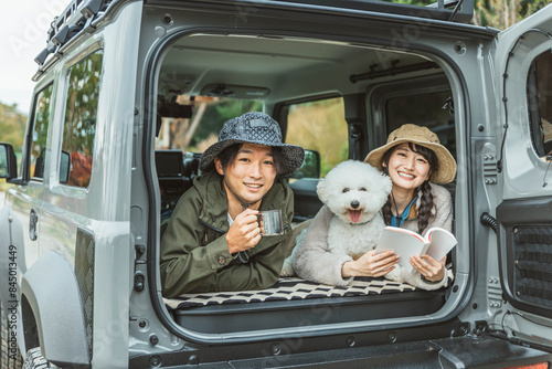 犬・ペットを連れてドライブ・デイキャンプ・キャンプ・車中泊する若いアジア人カップル・夫婦・キャンパー 