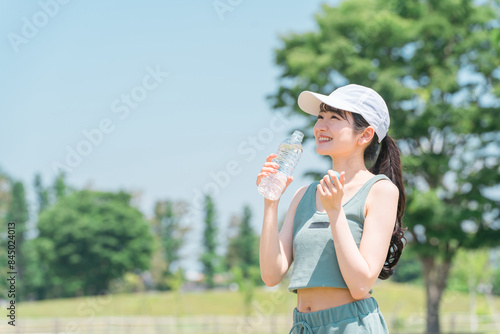 運動中に水・ミネラルウォーターを飲む女性（水分補給・運動・ワークアウト・ランニング・ウォーキング） 