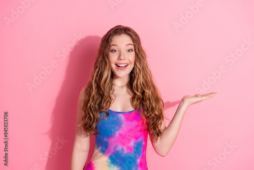 Photo of adorable lovely girl wear tank top showing arm empty space isolated pink color background