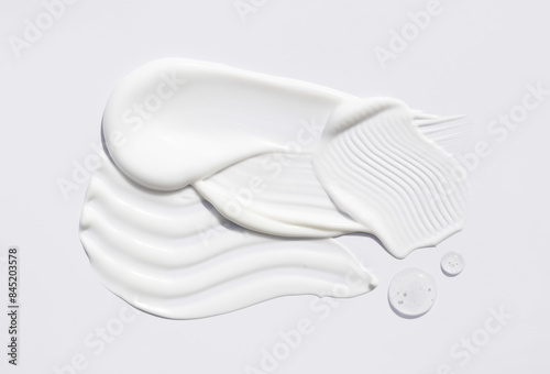 samples of cosmetic care products smear of cream and gel texture on a light background