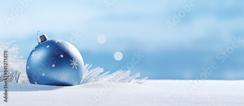 A blue Christmas ball rests on a small decorative sleigh placed on a snowy hill This image showcases the joyous festivities of winter holidays Perfect for a Merry Christmas and Happy New Year backgro