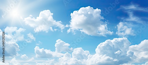 A sunny day with a beautiful clear blue sky and white clouds creates a bright and vibrant nature background image offering copy space The summer sky is filled with sunlight providing a textured and n