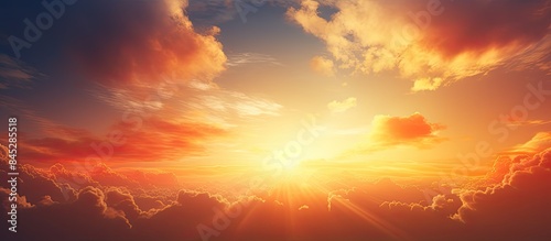 A breathtaking scene of an epic sky during sunrise or sunset painted with dramatic colors of orange and yellow featuring clouds and the radiant sun The image offers ample copy space