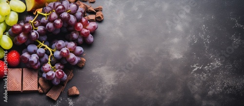 Healthy food concept with copy space image featuring fresh ripe grapes dark chocolate cocoa and apples on a concrete background These foods are rich in resveratrol and antioxidants