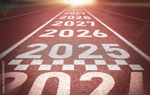 Start of new year. Changes of year 2025, 2026, 2027 on Running track. Concept of new ideas starting in new year, planning along with setting objectives to set KPI goals for success in life.