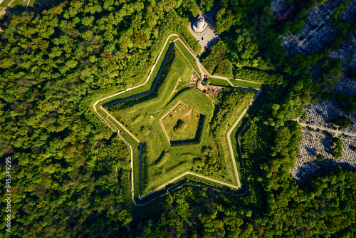 Aerial view of Prusy Fort in Nysa city on clear day, Star-shaped historical military fortress surrounded by lush greenery and the town in background. Tourist attraction in Poland