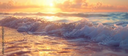 Captivating close-up of tranquil ocean waves under a golden sunrise or sunset sky. Stunning tropical island beach scenery with an exotic shoreline. 