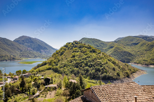 A view of Lake Turano, from the village of Castel di Tora, Rieti, Lazio, Italy. Mount Antuni, with its uninhabited village, stands in the center of the lake, surrounded by green mountains.