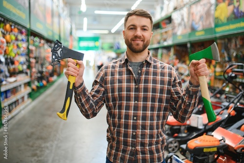 happy customer in a hardware store buying a new ax