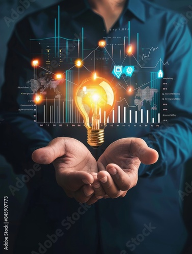 Businessman holding creative light bulb with growth graph, analytics icons. Utilizing analytics technology to develop new strategies and insights that enhance successful performance in global business