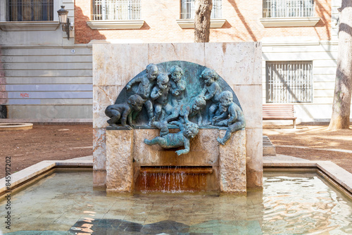 Valencia, Spain - May 30, 2024: Sculpture and fountain in Valencias Square: Children throw child into water. Popular Fuente de los Ninos Fountain of children by Spanish sculptor Mariano Benlliure Gil
