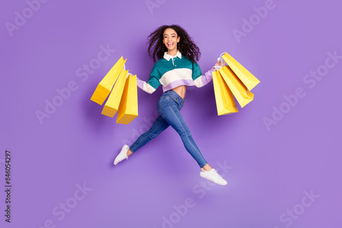 Full size photo of nice young girl jump shop bags wear shirt isolated on violet color background