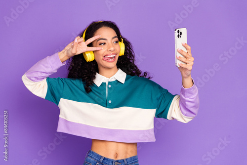 Photo of nice young girl make selfie v-sign wear shirt isolated on violet color background