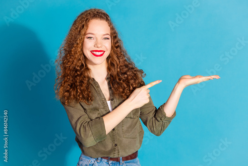 Portrait of pretty young woman direct finger hold empty space wear khaki shirt isolated on turquoise color background