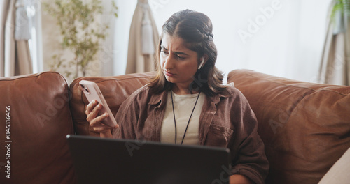 Thinking, woman and phone notification on sofa for entertainment, communication or internet browsing in home. Female person, thoughtful or concerned with laptop on couch for streaming or social media