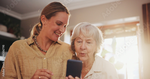 Senior, mother and woman with phone in home with helping for social media, online games and bingo app. Family, elderly person and discussion with smartphone for explaining, learning or happy in house