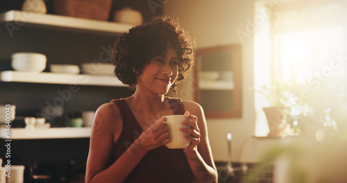 Woman, home and smile in kitchen with coffee in morning for warmth, relax and enjoy. Female person, house and happy or satisfied with cup of tea to chill, fun and day off with caffeine drink