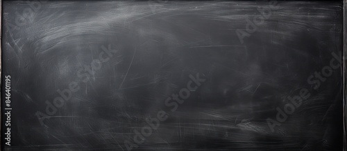 A blackboard with abstract chalk marks erased providing a textured background suitable for adding text or graphics in educational contexts Copy space image