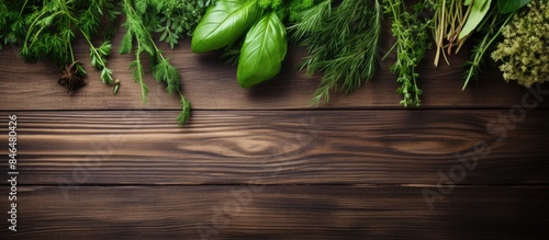 Fresh herbs sprinkled on a wooden background creating a copy space image