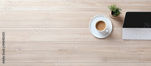 The office table is seen from above displaying a laptop a notepad and a cup of coffee There is enough free space for additional images or text