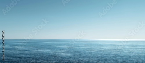 Vast blue ocean and a cloudless sky with room for text.