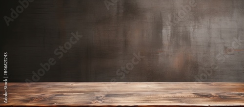 Wooden table displayed against a textured grunge wall background with copy space image.