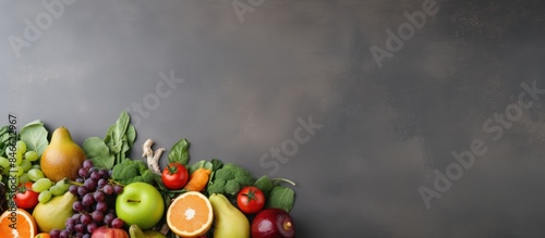 Assortment of healthy foods like fruits, vegetables, seeds, and cereals displayed on a gray concrete background with copy space image.
