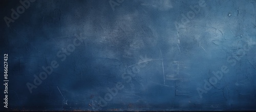 Beautiful abstract navy blue dark wallpaper with a grungy decorative look and a grainy texture on a painted blue wall, providing a great copy space image.