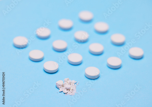 Pills, medication and pharmaceutical with crushed drugs in blue background for wellness, health or illness. Medicine, recovery and care for virus, flu or prescription by doctor for patient in clinic